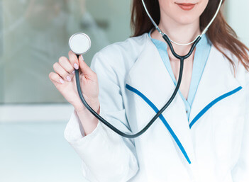 The female doctor with a stethoscope in the hands